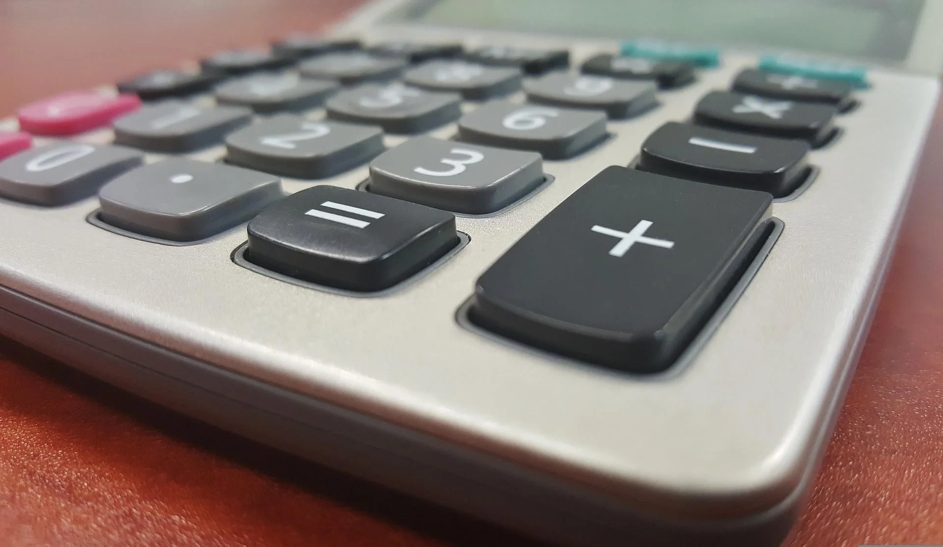 Uma família sorridente e aliviada, sentada em uma mesa moderna com um laptop exibindo um gráfico de finanças em alta e documentos de renegociação de dívidas, simbolizando a liberdade financeira após o Desenrola 2.0. Há também algumas notas de Real brasile