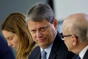 Dois políticos em debate acalorado, um mais jovem com camisa social e outro mais experiente de terno, com gráficos de infraestrutura e dinheiro ao fundo, simbolizando a disputa por investimentos em São Paulo.
