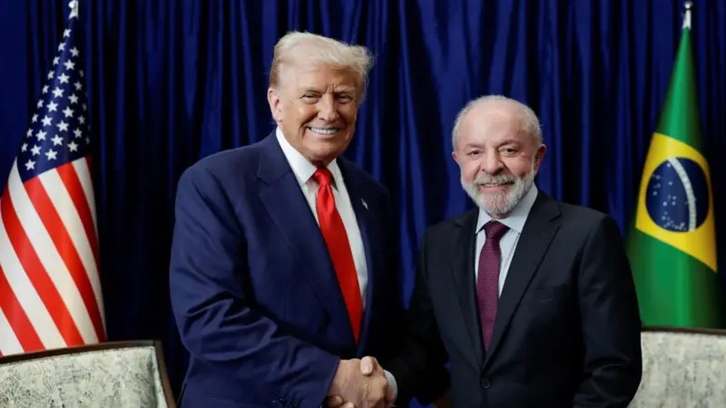 Um líder brasileiro idoso de cabelos brancos e terno escuro cumprimenta um líder americano loiro de gravata vermelha em um escritório clássico e luxuoso.