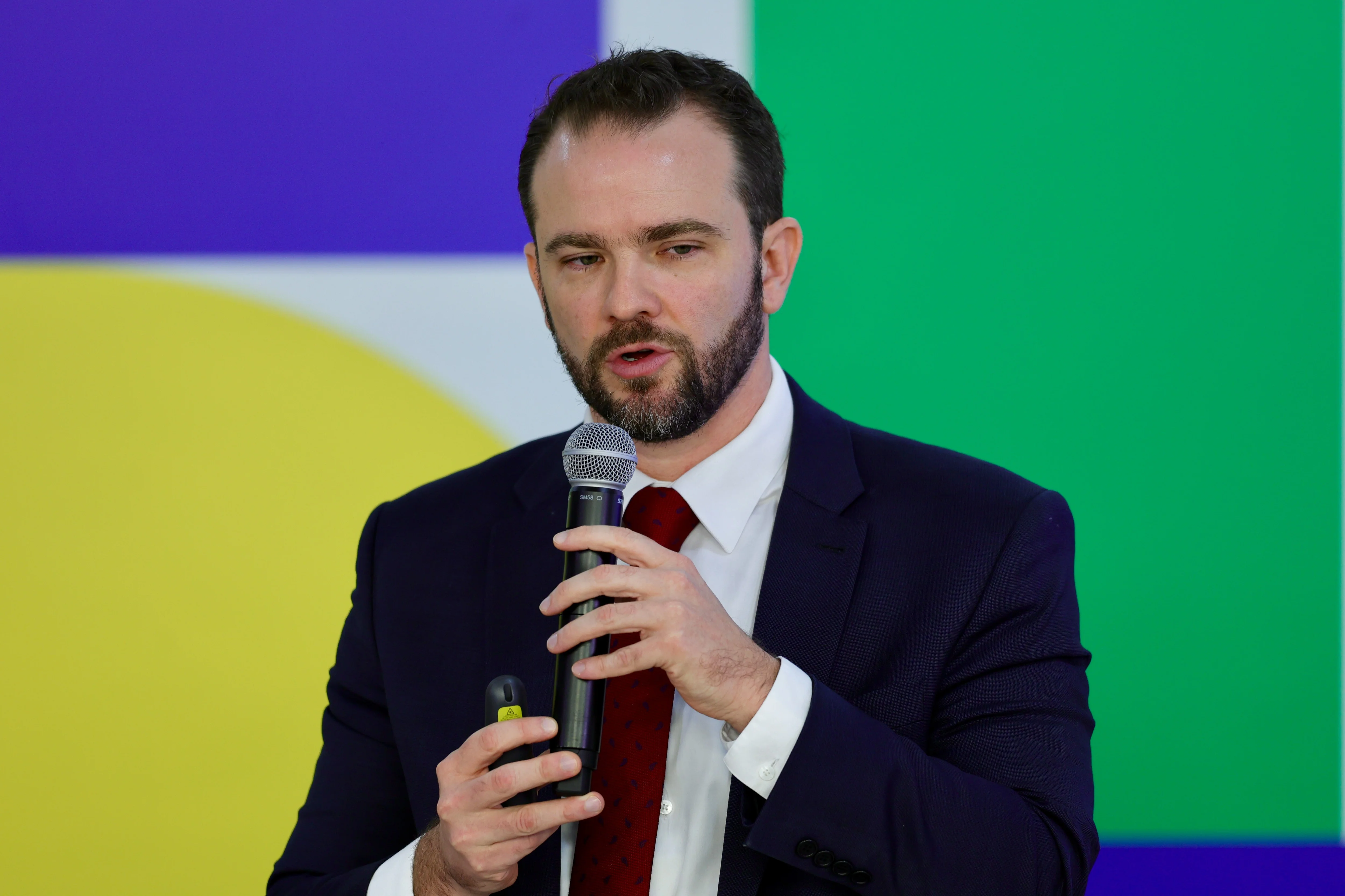 Um aperto de mãos entre um trabalhador informal (talvez um vendedor ambulante ou autônomo) e um representante financeiro, simbolizando a renegociação de dívidas. Ao fundo, elementos urbanos e gráficos de juros altos em declínio.