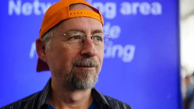 Representação artística do conceito de Satoshi Nakamoto, o criador anônimo do Bitcoin, em um ambiente digital e enigmático, com elementos de criptografia e códigos binários. Há um foco no mistério da identidade.