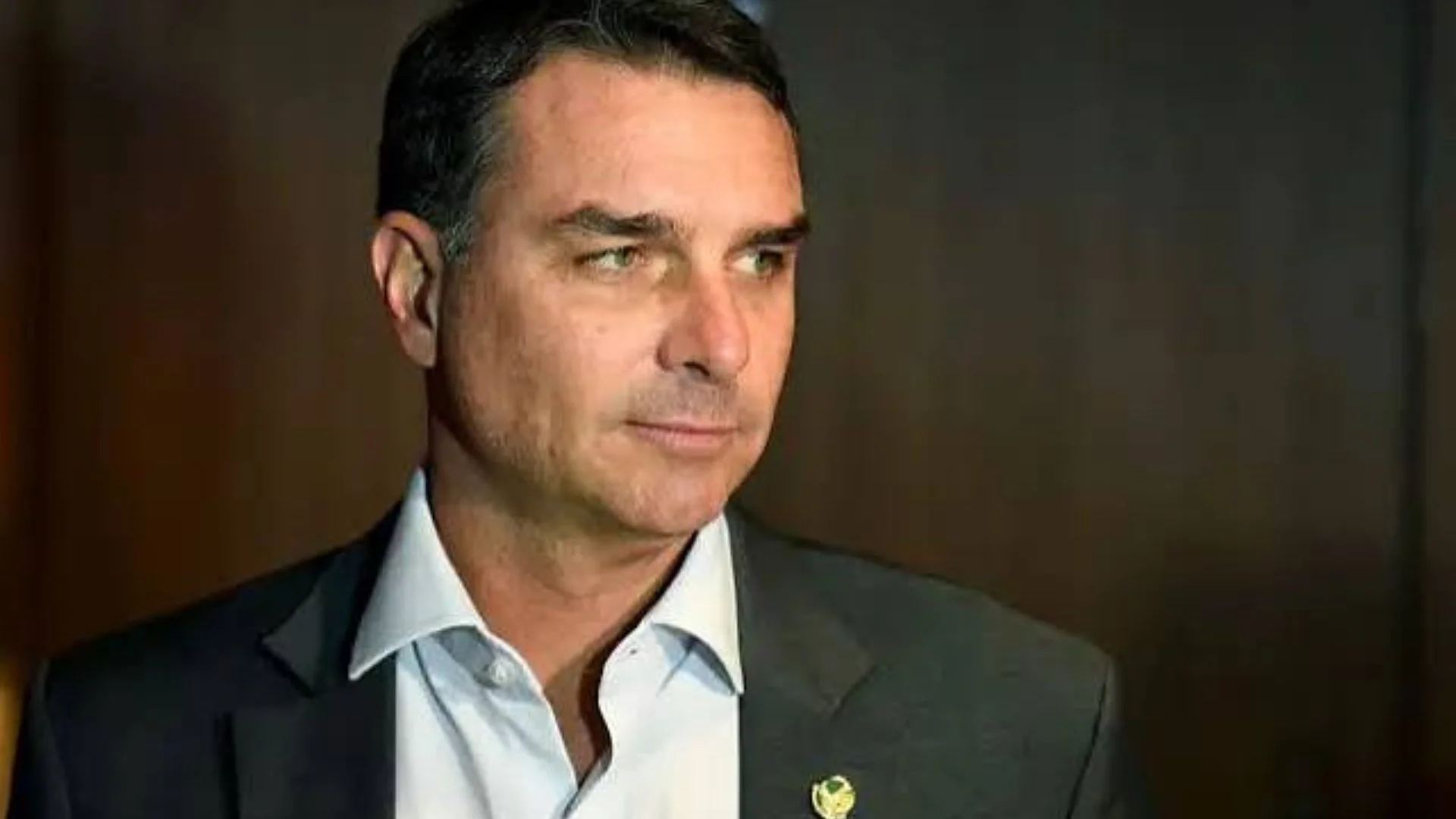 Um político brasileiro de terno escuro e cabelo curto, gesticulando em um pódio com microfones, enquanto um gráfico digital do Pix com símbolos de dinheiro e crescimento flutua ao fundo, em uma audiência internacional.