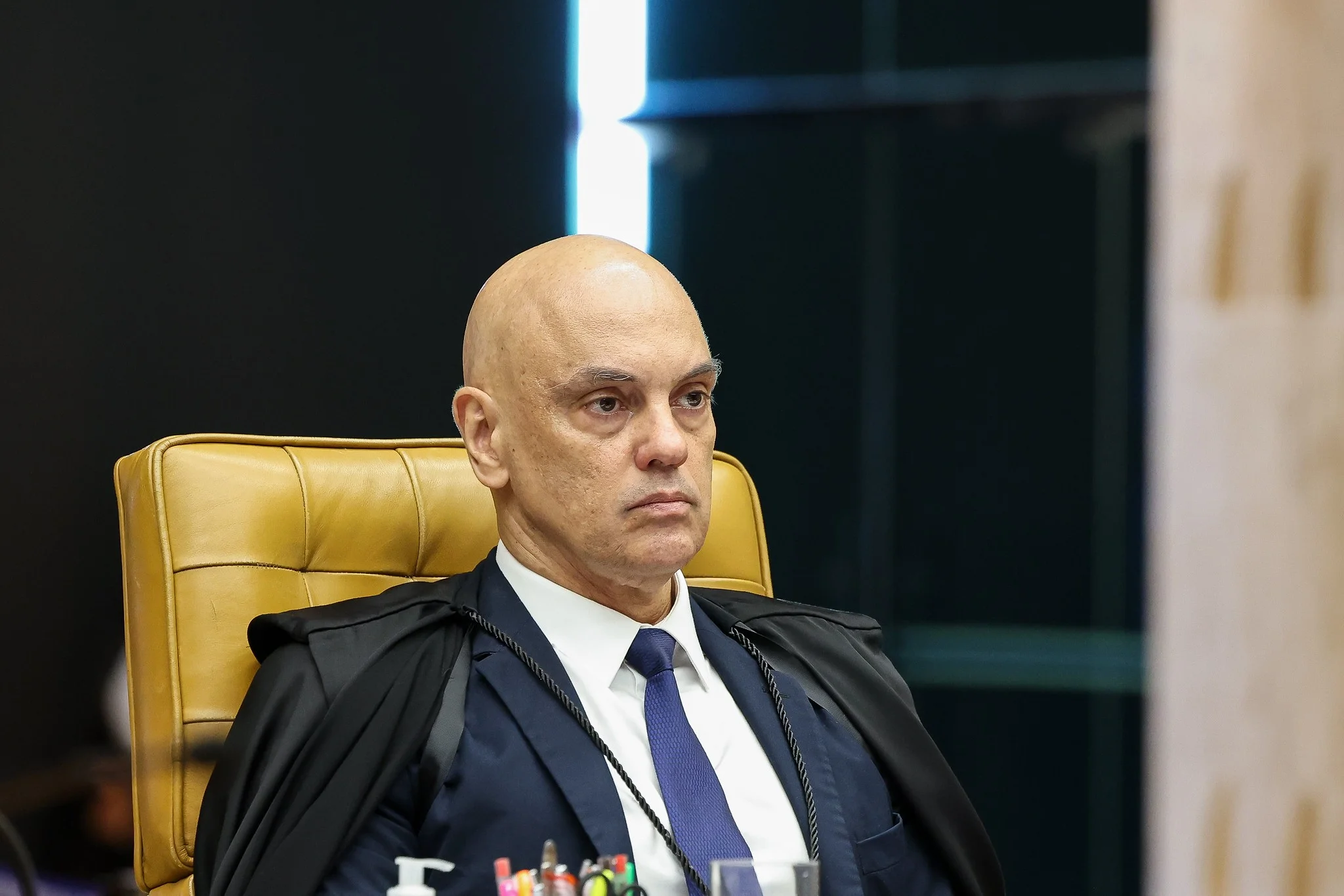 Três eurodeputados europeus em um ambiente parlamentar, discutindo documentos com símbolos da União Europeia e do Brasil ao fundo, enquanto um gráfico financeiro se sobrepõe, indicando o impacto econômico das decisões.
