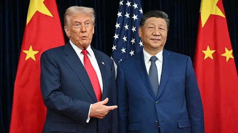Um tabuleiro de xadrez escuro onde as peças são barris de petróleo dourados e navios petroleiros, com as bandeiras de EUA e China refletidas na superfície polida.